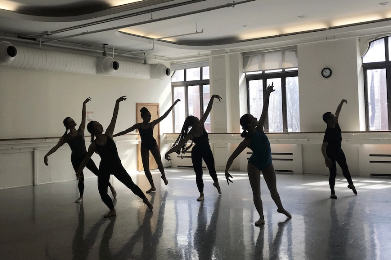Group of dancers, mid-sequence, in a rehearsal studio